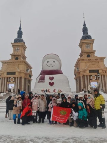 Super Travels tour group beside a giant snowman on a winter tour in Northeast China
