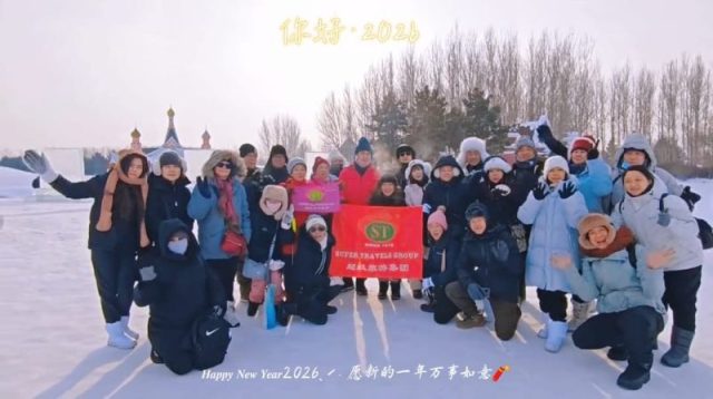 Super Travels tour group on a snowfield with a Happy New Year 2026 greeting, Northeast China