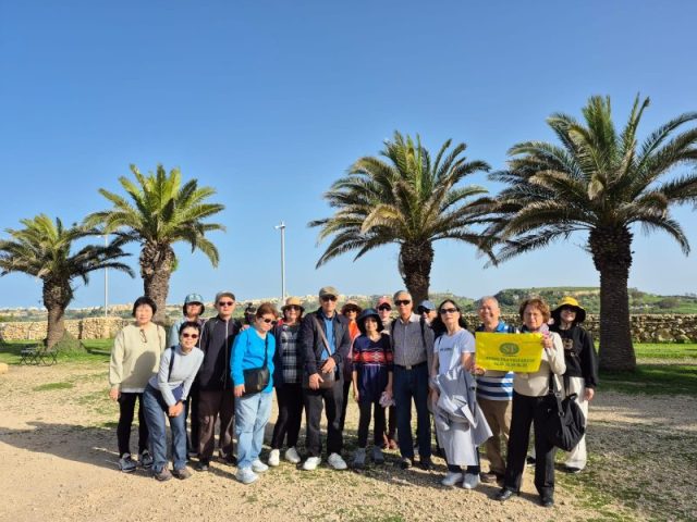 Super Travels tour group among palm trees on a Mediterranean coast
