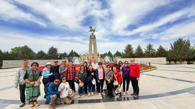 Super Travels tour group at a monument plaza in Inner Mongolia